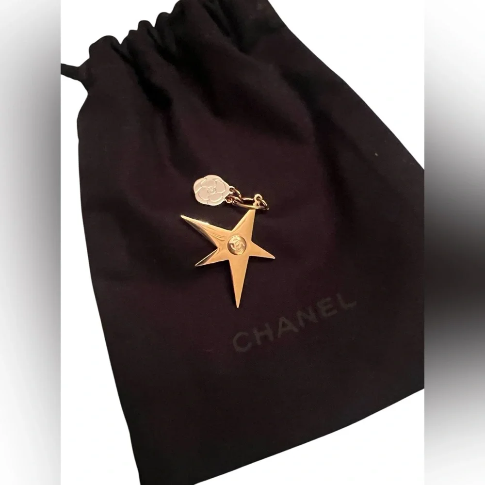 CHANEL Gold Star & small Camellia key Charm with black drawstring pouch.